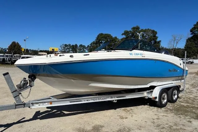 Slide: The Image of 2016 NauticStar 223 DC boat on trailer, blue and white design, parked outdoors. - 9