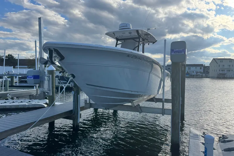 Slide: The Image of 2023 Sea Fox 268 Commander boat on lift at marina, under cloudy sky. - 3