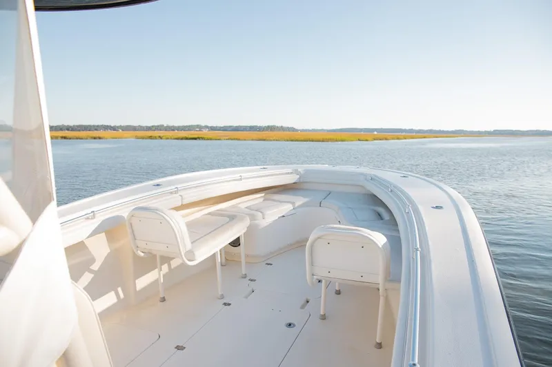 Slide: The Image of 2014 Yellowfin 34 Offshore boat on calm water, featuring spacious seating and sleek design. - 11