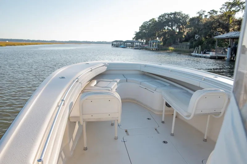 Slide: The Image of 2014 Yellowfin 34 Offshore boat interior with seating, cruising on a calm river. - 12