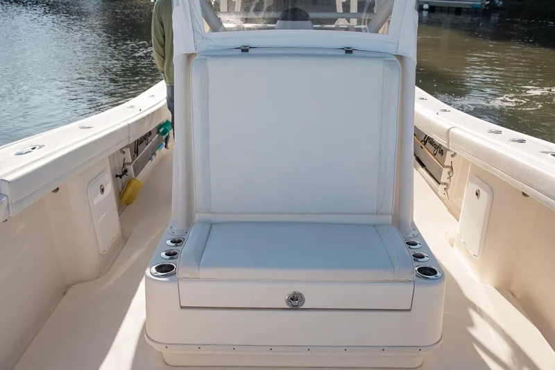Slide: The Image of 2014 Yellowfin 34 Offshore boat interior with cushioned seating and cup holders. - 14
