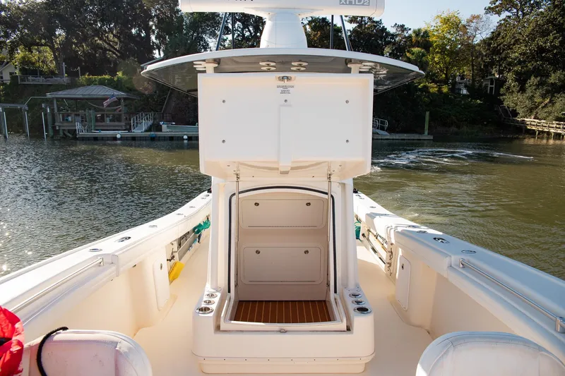 Slide: The Image of 2014 Yellowfin 34 Offshore boat interior with open storage, docked by a scenic waterfront. - 15