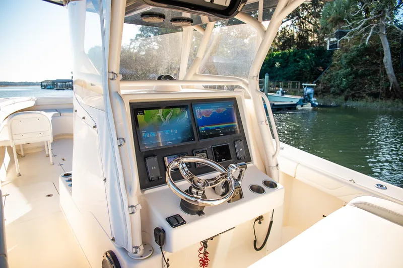 Slide: The Image of 2014 Yellowfin 34 Offshore boat cockpit with advanced navigation system and steering wheel. - 17
