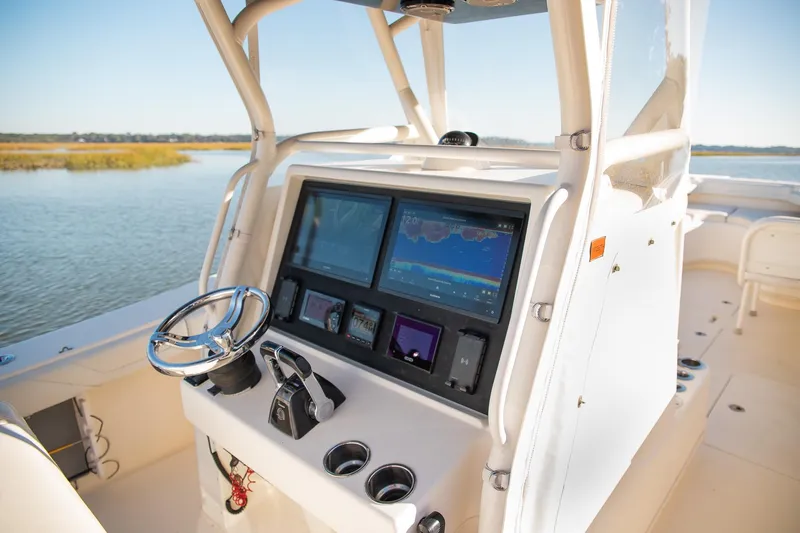 Slide: The Image of 2014 Yellowfin 34 Offshore boat console with advanced navigation system on calm water. - 18