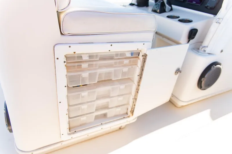 Slide: The Image of 2014 Yellowfin 34 Offshore boat storage compartment with open door and organized containers. - 29