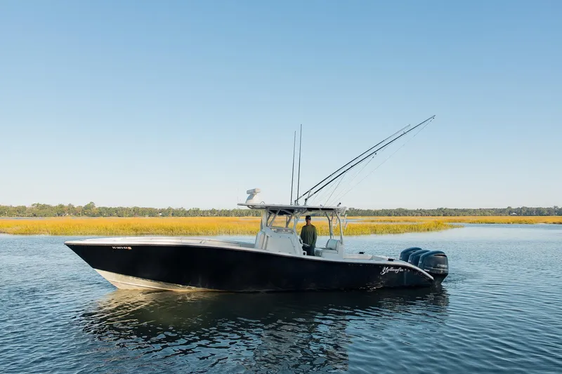 Slide: The Image of 2014 Yellowfin 34 Offshore boat on calm water, surrounded by marshland. - 3