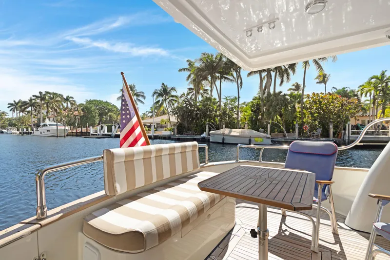 Slide: The Image of Luxury Noresman 480 Sedan yacht deck with seating, table, and American flag, 2006 model. - 42