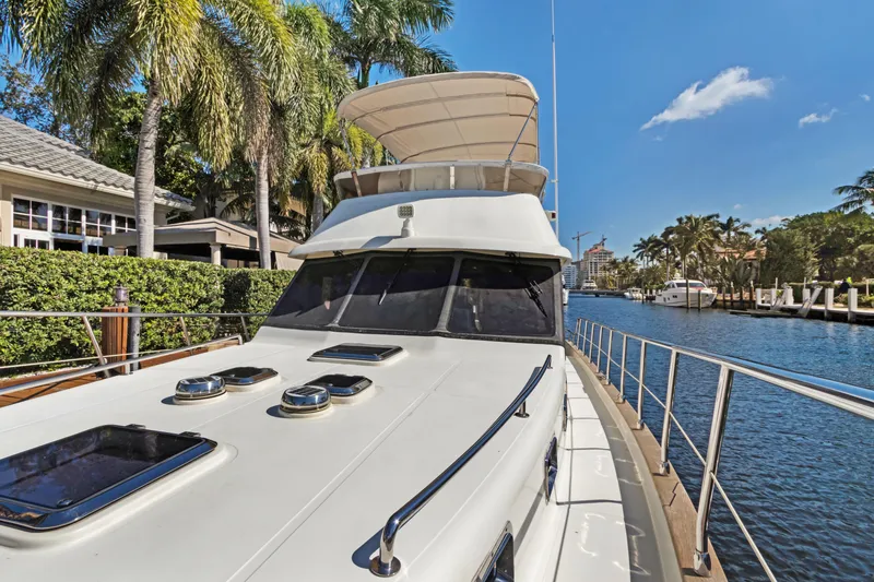 Slide: The Image of Luxury 2006 Noresman 480 Sedan yacht docked by palm trees and waterfront homes. - 47