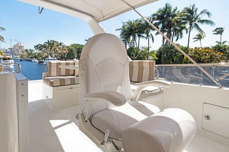 Slide: The Image of Luxury Noresman 480 Sedan yacht interior with plush seating, palm trees, and waterfront view. - 64