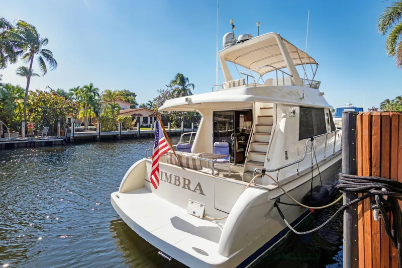 Slide: The Image of Luxury 2006 Noresman 480 Sedan yacht docked by palm trees and waterfront homes. - 68