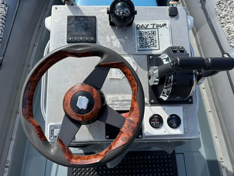 Slide: The Image of Steering console of 2012 Zodiac 733 Hurricane boat with wooden wheel and navigation controls. - 10