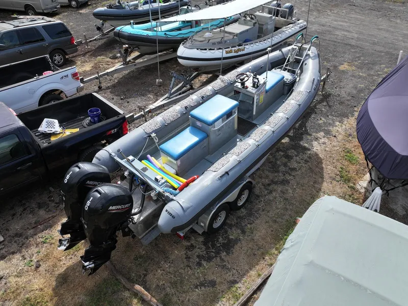 Slide: The Image of 2012 Zodiac 733 Hurricane boat with dual Mercury engines on a trailer in a parking area. - 3