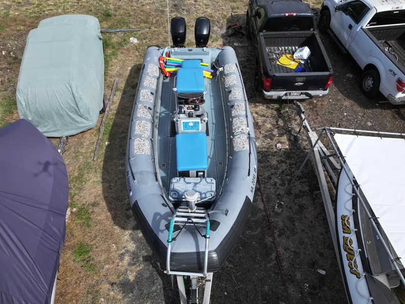 Slide: The Image of Overhead view of a 2012 Zodiac 733 Hurricane boat in a yard with vehicles. - 7
