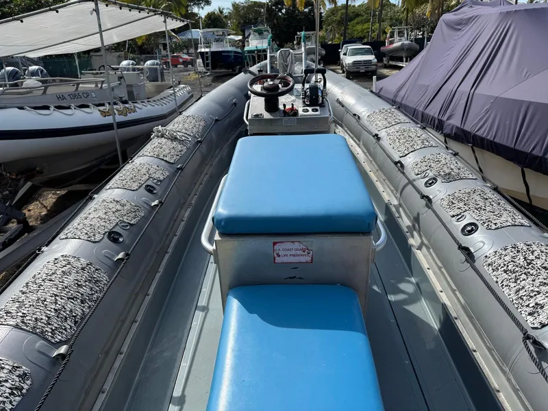 Slide: The Image of 2012 Zodiac 733 Hurricane boat with blue seating and steering console, docked outdoors. - 9
