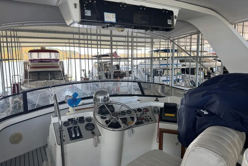 Slide: The Image of 1987 Carver 42 Aft Cabin Motor Yacht helm in marina, showcasing steering and controls. - 15