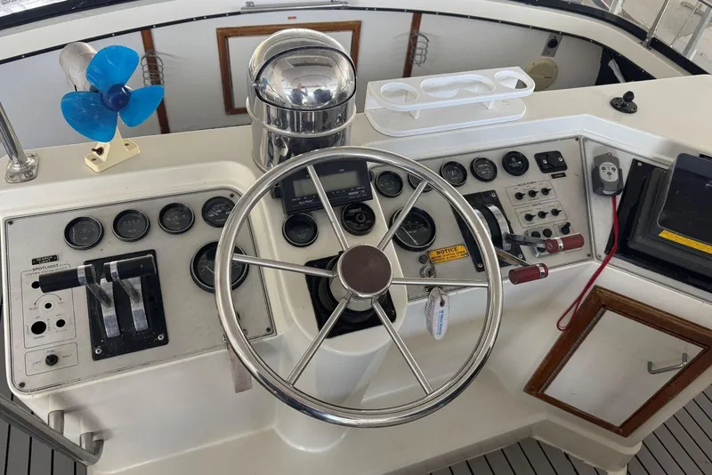 Slide: The Image of Control panel of a 1987 Carver 42 Aft Cabin Motor Yacht with steering wheel and gauges. - 17