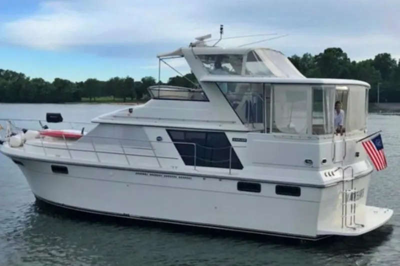 Slide: The Image of 1987 Carver 42 Aft Cabin Motor Yacht cruising on a serene lake. - 3