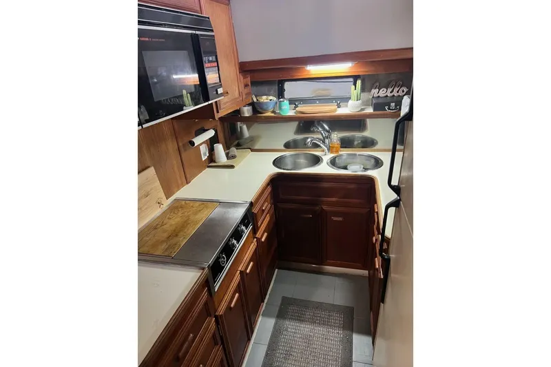 Slide: The Image of 1987 Carver 42 Aft Cabin Motor Yacht kitchen with wooden cabinets and dual sinks. - 35