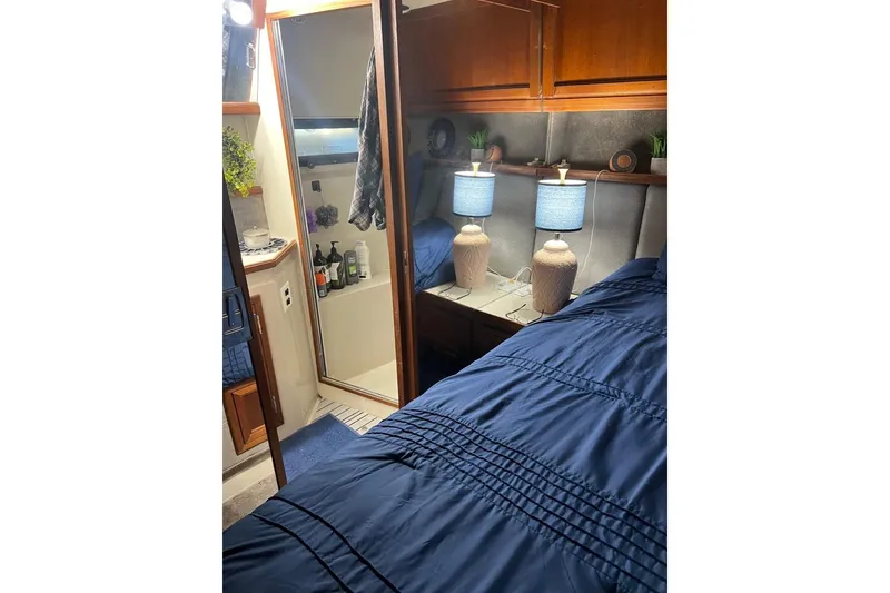 Slide: The Image of Cozy interior of 1987 Carver 42 Aft Cabin Motor Yacht with blue bedding and lamps. - 43