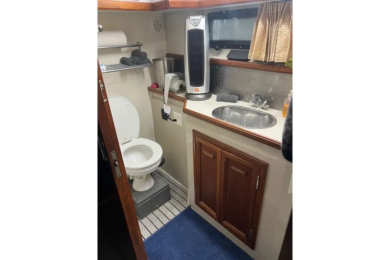 Slide: The Image of 1987 Carver 42 Aft Cabin Motor Yacht bathroom with sink, toilet, and storage cabinets. - 45