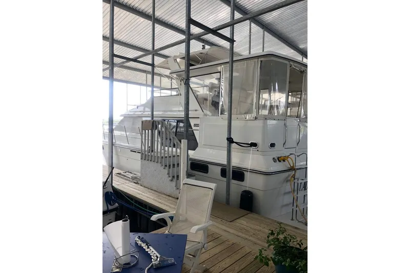 Slide: The Image of 1987 Carver 42 Aft Cabin Motor Yacht docked under a covered marina. - 8