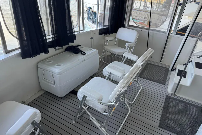 Slide: The Image of 1987 Carver 42 Aft Cabin Motor Yacht interior with chairs and cooler on deck. - 11
