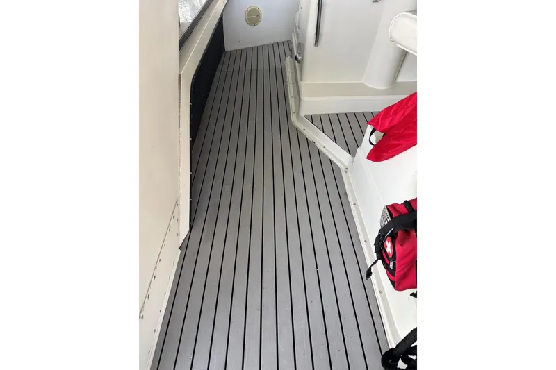 Slide: The Image of 1987 Carver 42 Aft Cabin Motor Yacht deck with striped flooring and red life jacket. - 14