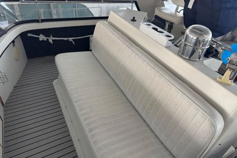 Slide: The Image of 1987 Carver 42 Aft Cabin Motor Yacht interior with cushioned seating and helm area. - 21