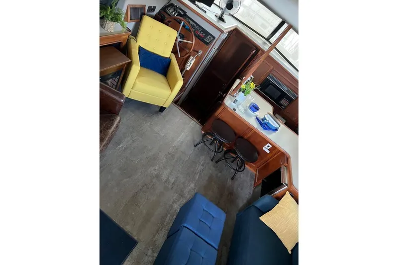 Slide: The Image of Interior of 1987 Carver 42 Aft Cabin Motor Yacht with vibrant seating and cozy decor. - 24