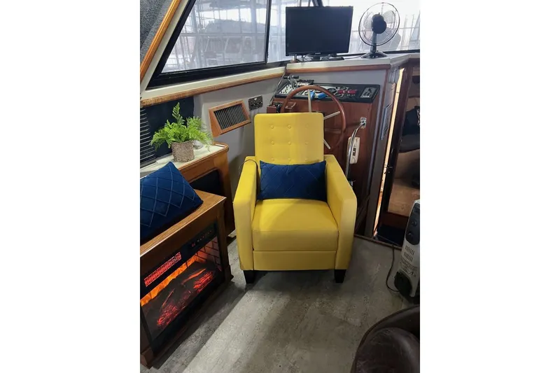 Slide: The Image of Cozy interior of 1987 Carver 42 Aft Cabin Motor Yacht with yellow chair and fireplace. - 27