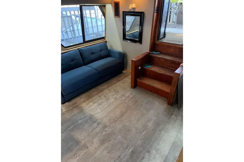 Slide: The Image of Interior of 1987 Carver 42 Aft Cabin Motor Yacht with blue sofa and wooden stairs. - 30