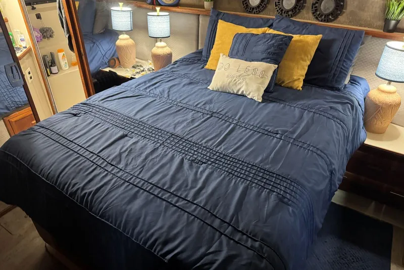 Slide: The Image of Cozy bedroom in 1987 Carver 42 Aft Cabin Motor Yacht with blue bedding and decorative pillows. - 40