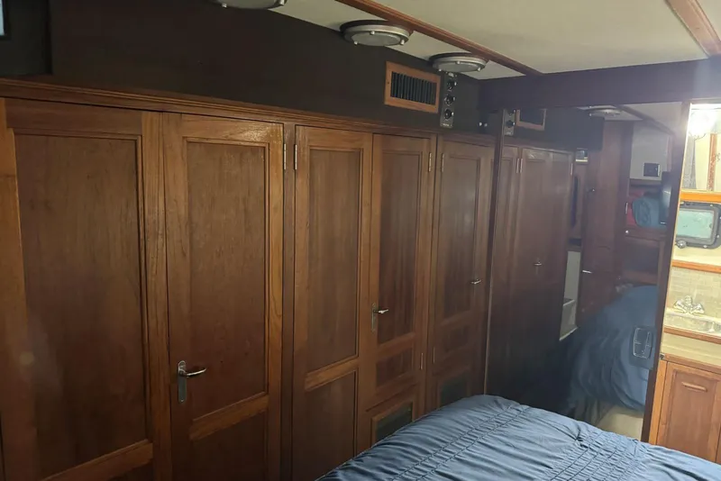 Slide: The Image of 1987 Carver 42 Aft Cabin Motor Yacht interior with wooden cabinetry and cozy bedroom. - 42