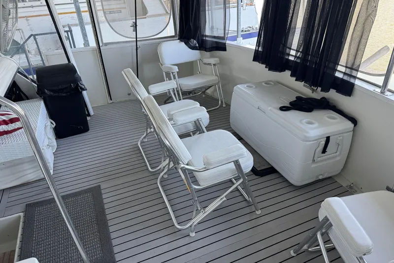Slide: The Image of 1987 Carver 42 Aft Cabin Motor Yacht interior with chairs and cooler on deck. - 9