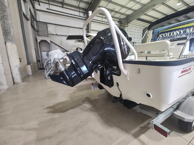 Slide: The Image of 2022 Boston Whaler 190 Montauk boat with outboard motor in a warehouse setting. - 11