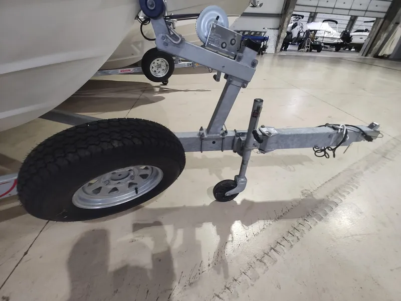 Slide: The Image of Trailer hitch and wheel of 2022 Boston Whaler 190 Montauk boat in a showroom. - 12