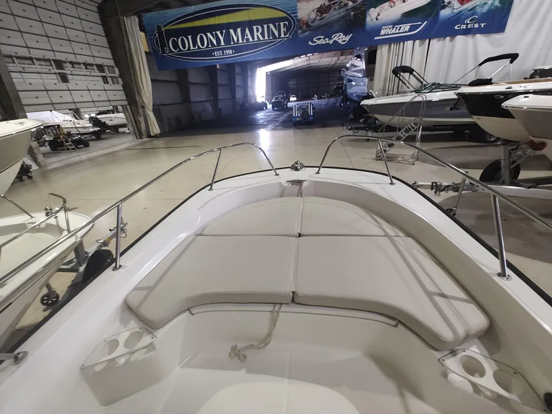 Slide: The Image of 2022 Boston Whaler 190 Montauk boat interior in a showroom with other boats. - 16