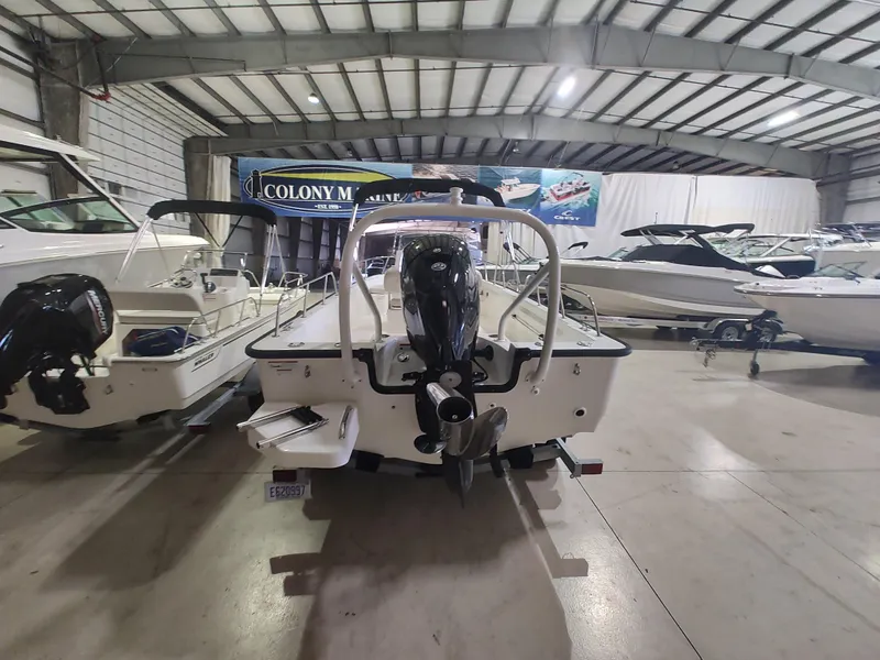 Slide: The Image of 2022 Boston Whaler 190 Montauk boat in showroom, rear view with outboard motor. - 2