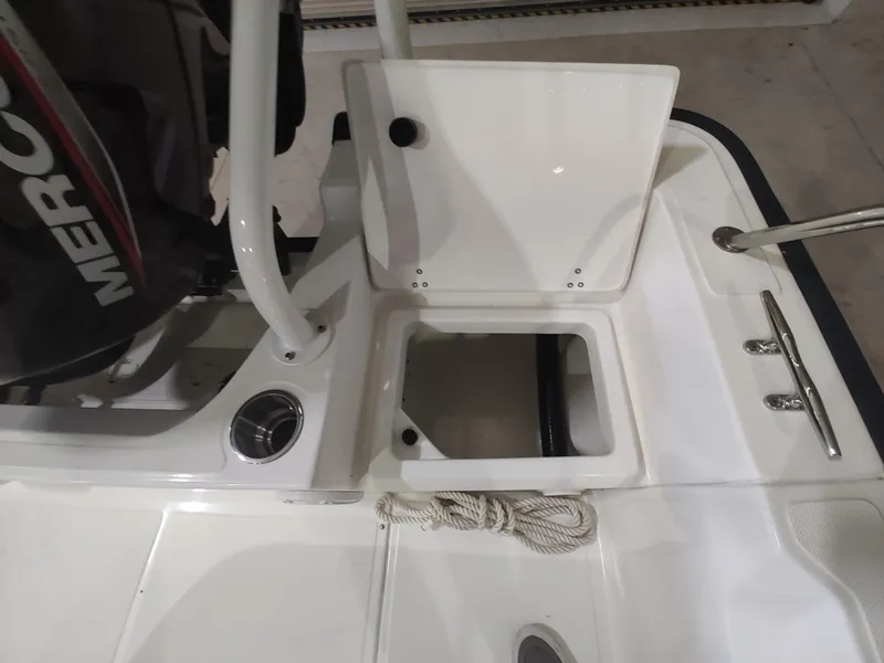 Slide: The Image of 2022 Boston Whaler 190 Montauk boat deck with storage compartment and Mercury engine. - 22