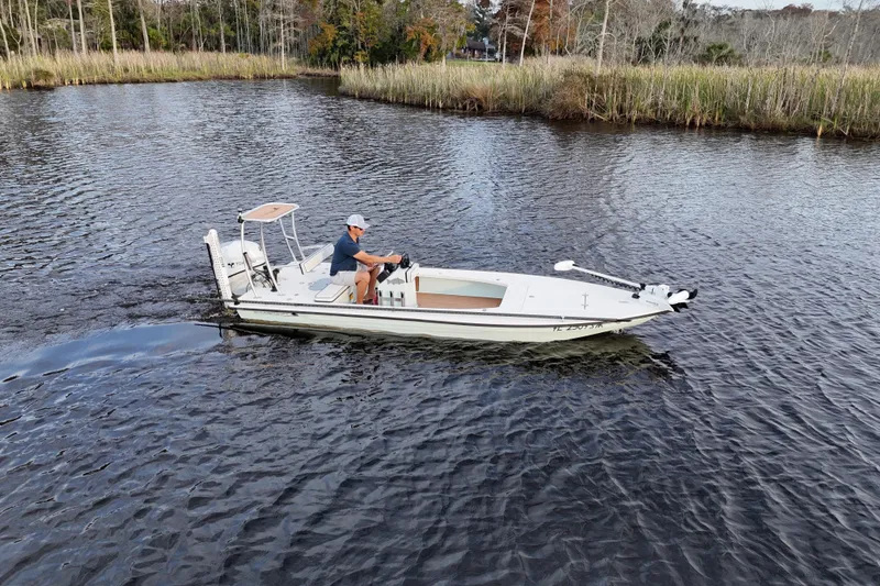 Slide: The Image of 2019 Skimmer Skiff 16'6" CC boat navigating a calm river with lush greenery. - 29