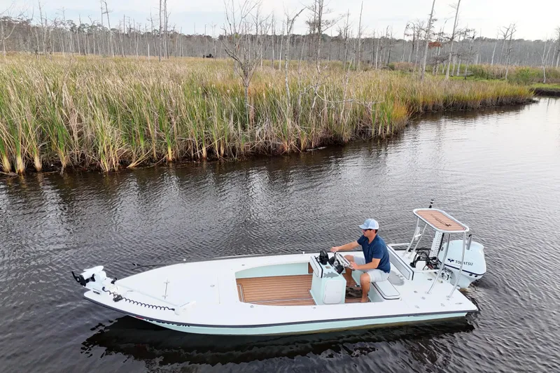Slide: The Image of 2019 Skimmer Skiff 16'6" CC boat navigating through marshland waters. - 30