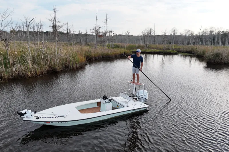 Slide: The Image of Man on 2019 Skimmer Skiff 16'6" CC boat in marshland, holding a pole. - 33