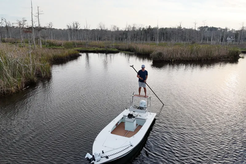 Slide: The Image of Man on 2019 Skimmer Skiff 16'6" CC boat in marshland, holding a pole. - 34