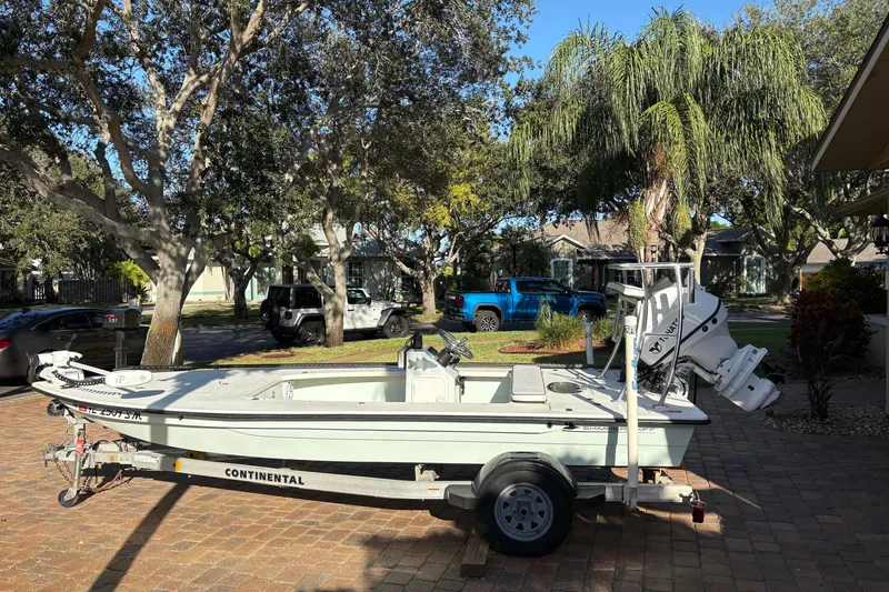 Slide: The Image of 2019 Skimmer Skiff 16'6" CC boat on trailer in a sunny residential area. - 38