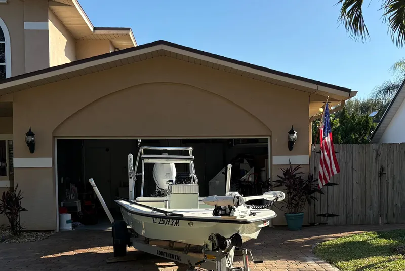 Slide: The Image of 2019 Skimmer Skiff 16'6" CC boat parked in front of a garage with American flag. - 41