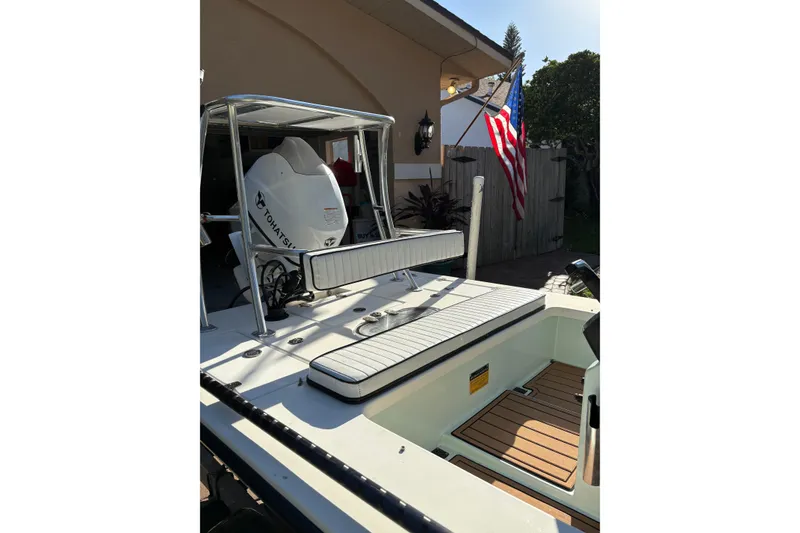 Slide: The Image of 2019 Skimmer Skiff 16'6" CC boat with Tohatsu engine, parked near a house. - 52