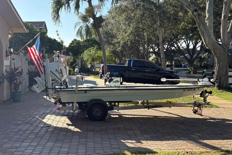 Slide: The Image of Man steering 2019 Skimmer Skiff 16'6" CC boat on a calm river. - 8