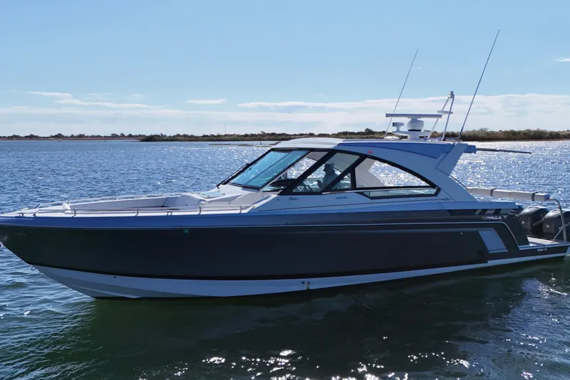Slide: The Image of 2021 Formula 400 Super Sport Crossover boat on calm water, side view. - 10