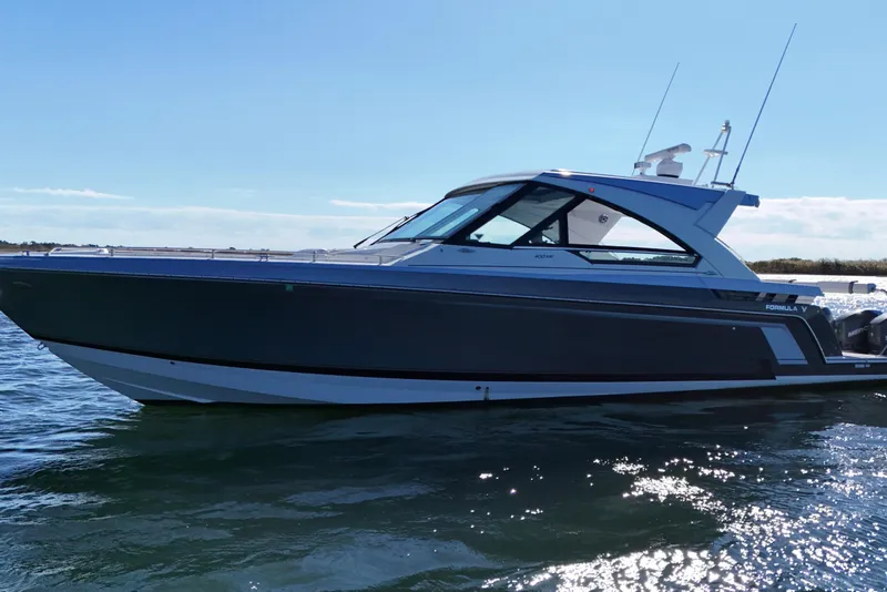 Slide: The Image of 2021 Formula 400 Super Sport Crossover boat on water, sleek design, sunny day. - 24