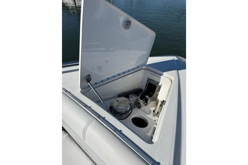 Slide: The Image of 2021 Formula 400 Super Sport Crossover boat anchor compartment open on water. - 58